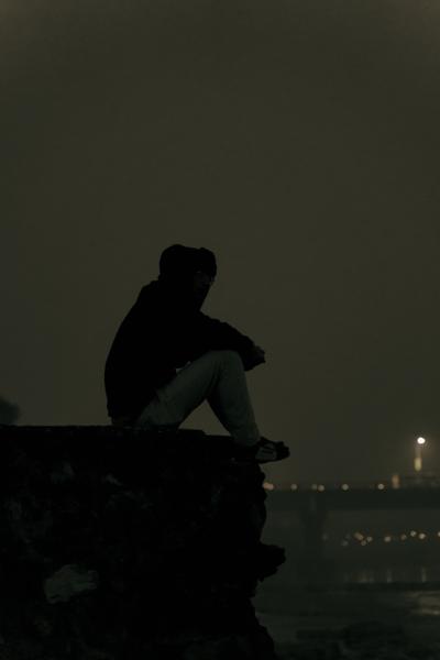 An image of a boy sitting in a rock hoping for good life , recalling his past event-banrupi